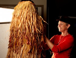 Artist Ruth Port with her weaving titled He Kakahu o Papatuanuku.